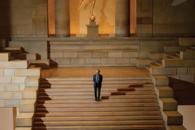 A man standing on a grand staircase.