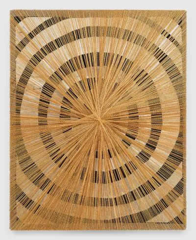 A black-and-white target painting covered by several gold chains knotted together in the center of the canvas.
