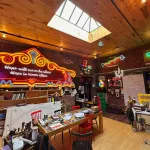 View of a studio with various neon works all around and a skylight above.