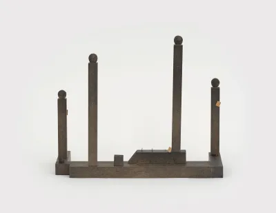 A sculpture that is a deconstructed table with no top, upside and just the legs.