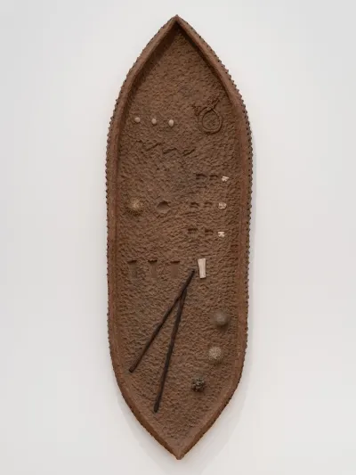 A wall-hung ovular papier-mâché artwork.