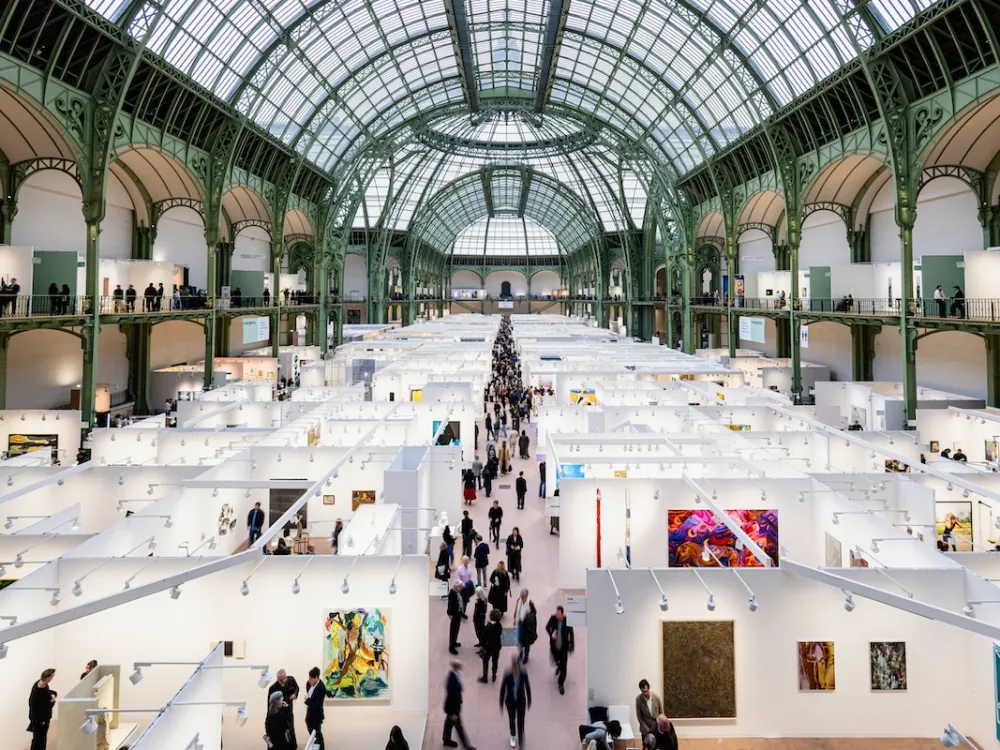 People walking among booths in a domed building.