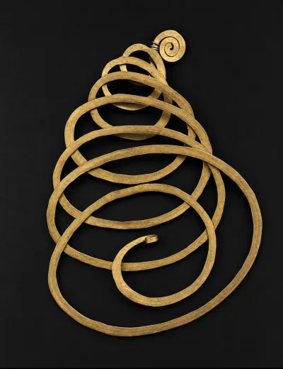A brass necklace made of various looping circles.