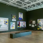 A gallery hung Salon-style with paintings.