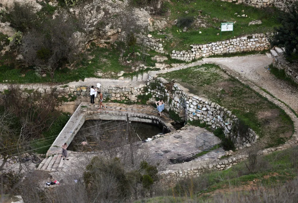 This picture shows a natural pool of water in the centre of the Palestinian village of Lifta, which was abandoned during fighting in the 1948 Arab-Israeli war, on the outskirts of Jerusalem, on December 30, 2022. Lifta, a rare example of a still existing abandoned Palestinian village, lies in a bucolic spot at the entrance to Jerusalem, and is at the centre of a preservation fight over an Israeli plan to build villas there.The village, in mainly Jewish west Jerusalem, is on a tentative list of UNESCO World Heritage sites. The World Monuments Fund organisation has put it on its list of sites under threat.
