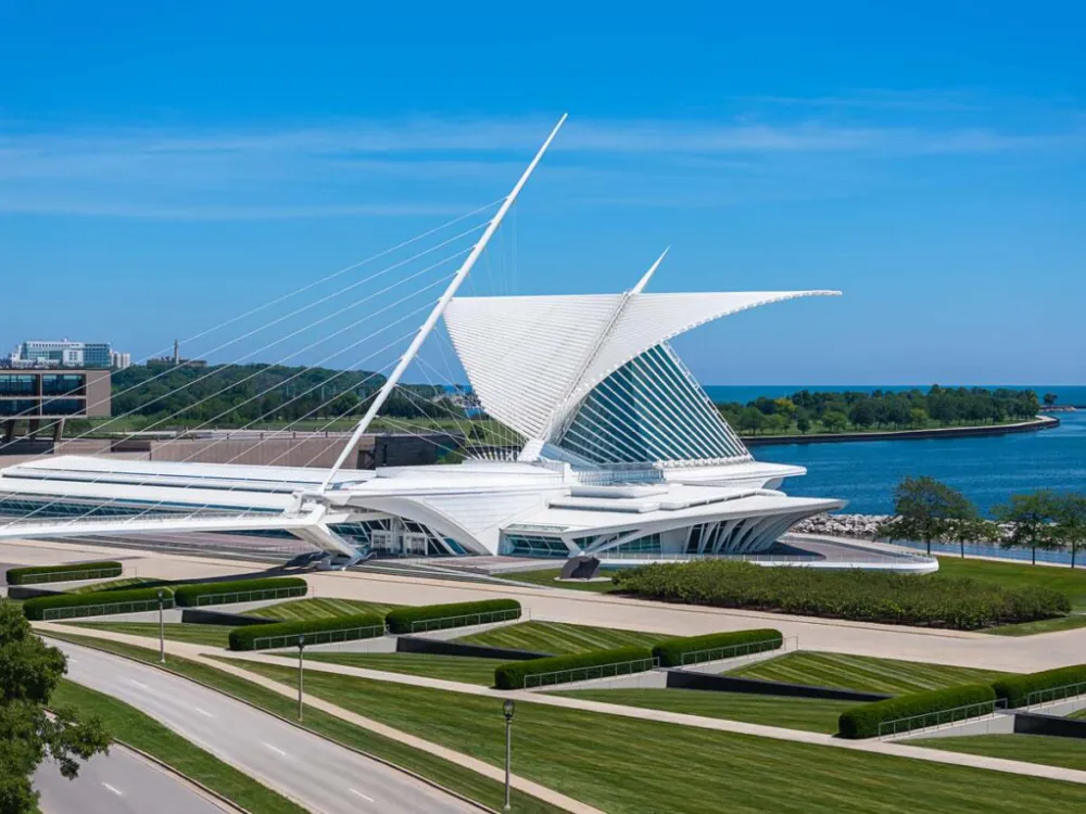 A white building against a lake that resembles a ship.