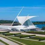 A white building against a lake that resembles a ship.