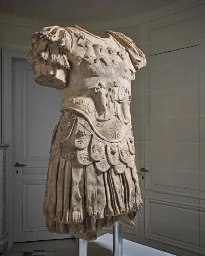 A photo shows a marble sculpture of the torso of a Roman emperor, with detailed armor and regalia